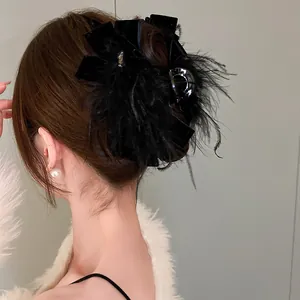 Dettaglio vista posteriore di un'elegante pinza per capelli in velluto nero con piume