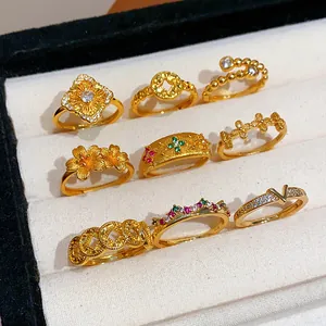 Vista dettagliata di vari anelli aperti placcati oro in un vassoio display stile vintage