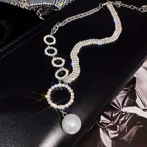 Détail élégant d'un collier ras du cou en strass argenté avec un pendentif perle