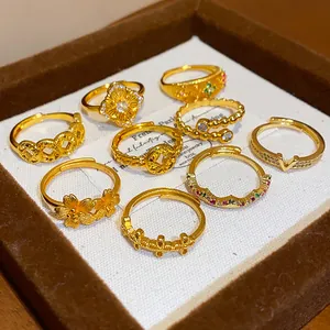 Primo piano di alta qualità di anelli vintage placcati oro con motivi floreali e monete