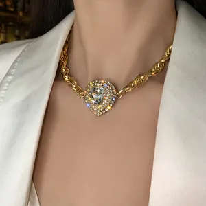 Gros plan d'un collier chaîne dorée avec un pendentif cœur étincelant en strass
