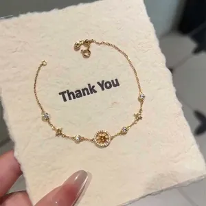 Vue détaillée d'un bracelet boussole en or avec étoile à huit branches et pierres de zircon