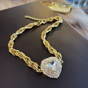 Gros plan d'un collier cœur doré élégant avec des strass étincelants