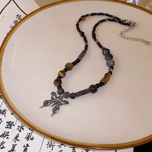 Vue détaillée d'un collier de perles Zen avec pendentif papillon en argent vintage.