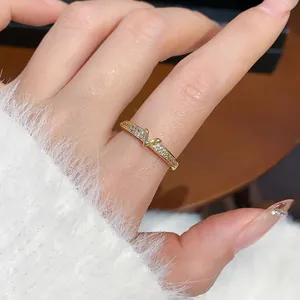 Dettaglio macro di un elegante anello a V placcato in oro con cristalli sul dito