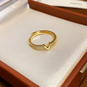 Dettaglio di un anello aperto placcato oro con motivo a V e pavé di cristalli fini