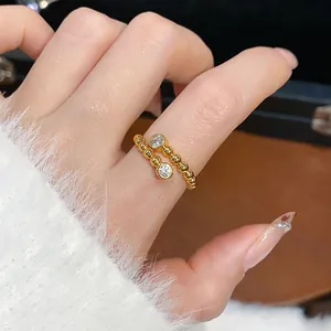 Anello aperto con perline placcato oro e cristalli indossato con un maglione bianco