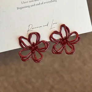 Detailed macro view of red openwork flower earrings with a vintage flocked texture finish