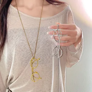 Detailed macro view of stylish metal glasses pendant necklaces in gold and silver finish