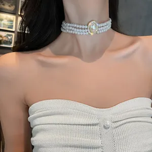 Gros plan élégant d'un collier ras du cou à trois rangs de perles avec cristal central