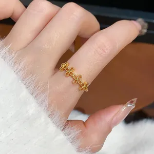 Primo piano di un anello aperto retrò placcato oro con motivo floreale su un dito