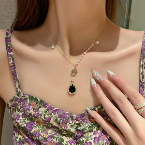 Vue macro détaillée d'un élégant collier avec pendentif en forme de goutte noire.