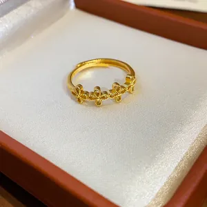 Dettaglio di un anello regolabile placcato oro con motivi floreali in una scatola regalo