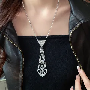 Detailed macro view of a sparkling rhinestone necktie-shaped tassel necklace on a model