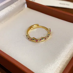 Primo piano di anello aperto placcato oro con pietre colorate in scatola regalo