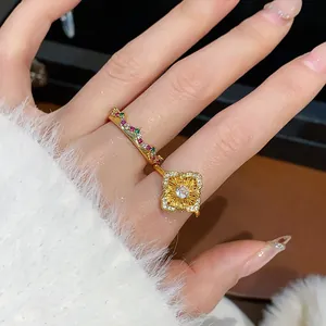 Dettaglio di un anello vintage placcato oro con un motivo floreale portato al dito