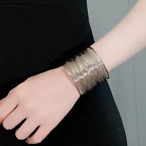 Close-up detail of a minimalist multi-layer silver wire wrap bangle with an open cuff design