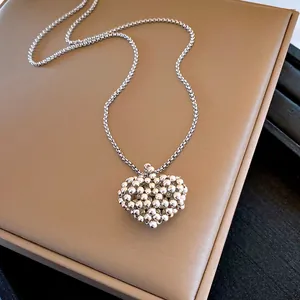Primer plano de un collar con colgante de corazón plateado retro con diseño de cuentas finas