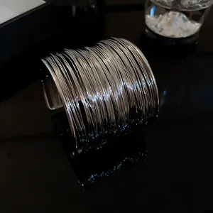 Detailed view of a silver multi-layer wire cuff bracelet with a modern minimalist style.
