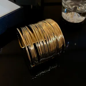 Detailed macro view of a golden multi-layered wire open cuff bracelet designer bangle