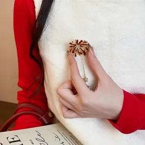 Close-up of elegant firework flower brooch with rhinestones and golden chain detail