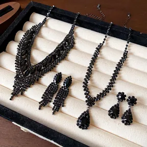 Detailansicht von schwarzen Strass Halsketten und Ohrringen in einem Tablett.
