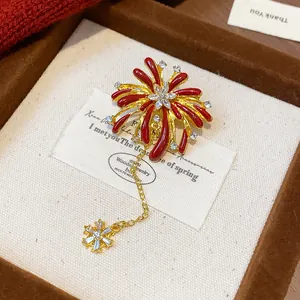 Detailed view of gold-toned firework brooch with red enamel and crystals