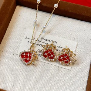 Elegant gold-plated jewelry set with heart-shaped pendants and pearls in a gift box