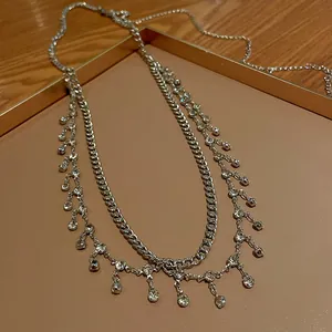 Vue détaillée de la chaîne de taille argentée à double rangée et franges de strass.