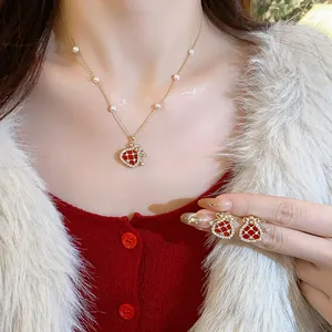 Close-up of elegant zircon-encrusted red fortune bag necklace and earrings jewelry set.