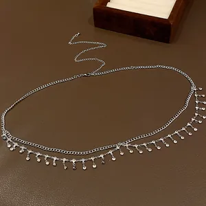 Gros plan sur une chaîne de taille argentée à double rangée avec des glands en strass