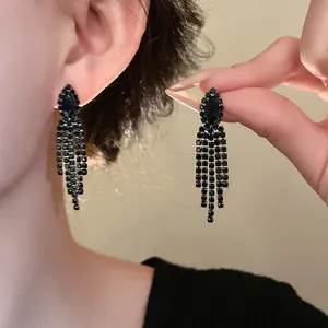 Detaillierte Ansicht eleganter schwarzer Strass-Ohrhänger, die am Ohr getragen werden