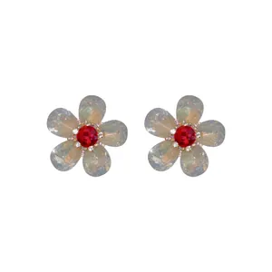 Elegantes pendientes de flores con centros de piedras rojas y pétalos iridiscentes