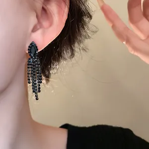 Elegante lange schwarze Strass-Ohrringe mit Quasten, am Modell für festliche Abendmode gezeigt