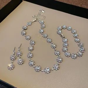 Dettaglio ravvicinato di un set di gioielli a fiore in strass argento con collana e bracciale.