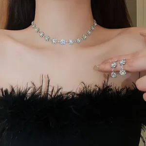 Primo piano di set collana e orecchini a fiori con strass scintillanti su modella