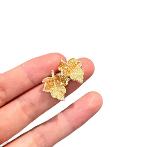 Elegantes pendientes de hoja de arce en plata bañada en oro con circonitas amarillas