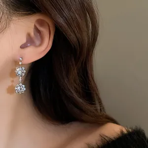 Dettaglio di eleganti orecchini a fiore in argento con cristalli scintillanti su modella