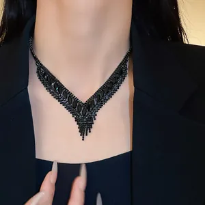 Detaillierte Ansicht der eleganten schwarzen Strass-Halskette am Hals des Models