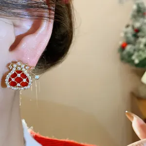 Close-up detail of a festive red fortune bag earring with gold plating and zircon stones