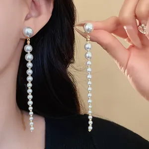 Close-up of elegant long pearl tassel earrings with a charming vintage French style.