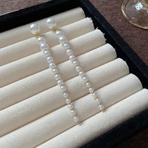 Detail of elegant long pearl tassel drop earrings in a velvet jewelry box