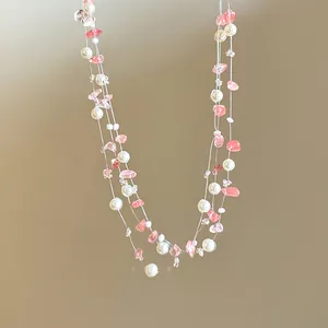 Detailed macro view of a sweet pink strawberry quartz and pearl layered necklace for women.
