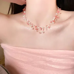 Close-up view of a sweet strawberry crystal and pearl multi-strand necklace on model