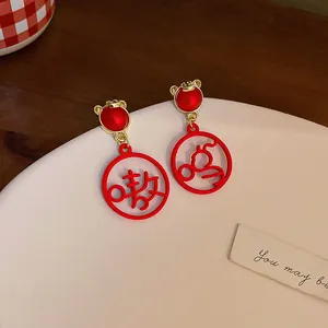 Close-up of festive red drop earrings with cute tiger design and character