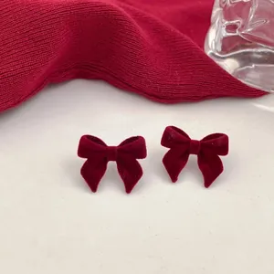 Detailed macro shot of elegant dark red velvet bow stud earrings with 925 silver needle