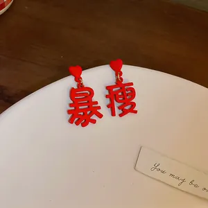 Detailed view of red heart earrings featuring Chinese characters for slimming down