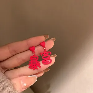 Detailed view of red heart earrings featuring 'Baofu' Chinese character charms.