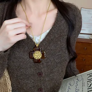Vintage amber flower pendant necklace detail worn with a stylish brown knit cardigan