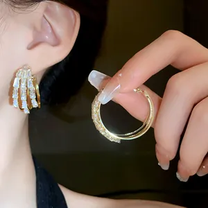Elegante dreilagige goldene Creolen mit Baguette-Kristallen in einer Nahaufnahme gezeigt